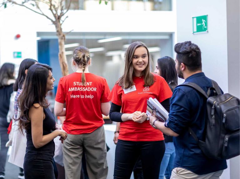A student ambassador and staff member helping a student during an event
